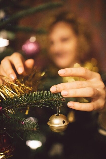 Foto vrouw die kerstboom versiert thuis