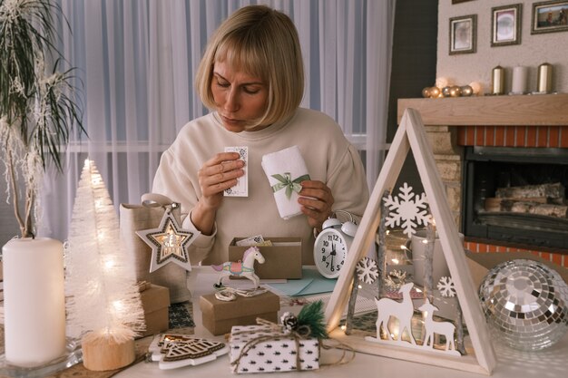 Vrouw die kerstcadeaus inpakt, cadeau inpakt voor kerstcadeautjes en nieuwjaar. Vakantie geschenkdozen versieren. Voorbereiding voor Kerstmis. Wintervakantie, woondecoratieconcept