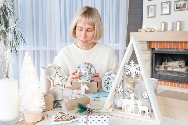 Vrouw die kerstcadeaus inpakt, cadeau inpakt voor kerstcadeautjes en nieuwjaar. Vakantie geschenkdozen versieren. Voorbereiding voor Kerstmis. Wintervakantie, woondecoratieconcept