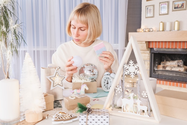 Vrouw die kerstcadeaus inpakt, cadeau inpakt voor kerstcadeautjes en nieuwjaar. Vakantie geschenkdozen versieren. Voorbereiding voor Kerstmis. Wintervakantie, woondecoratieconcept