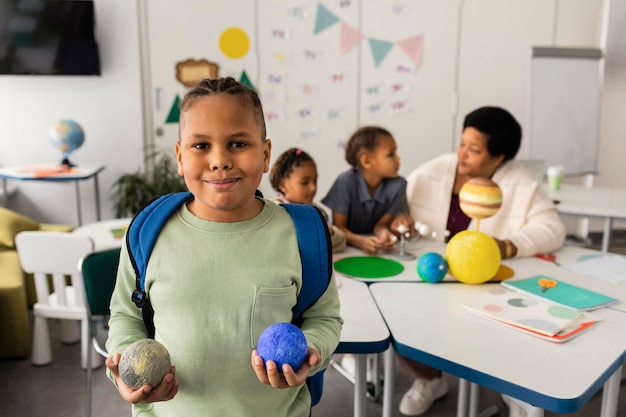 Vrouw die kinderen over planeten onderwijst