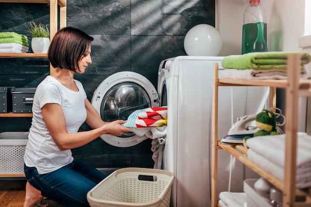 Vrouw die kleren uit wasmachine haalt
