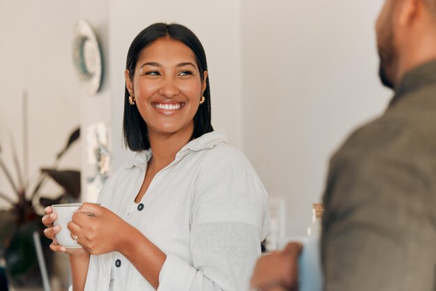 Vrouw die koffie drinkt met een gesprek en binding met haar man thuis Glimlachende gelukkige en ontspannen vrouw die geniet van quality time romantisch en vredig moment als een paar in liefdevolle relatie