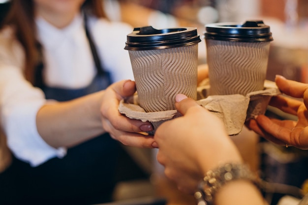 Vrouw die koffiedranken neemt bij een koffiewinkel