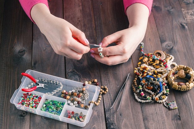 Vrouw die kralen armband met haar handen