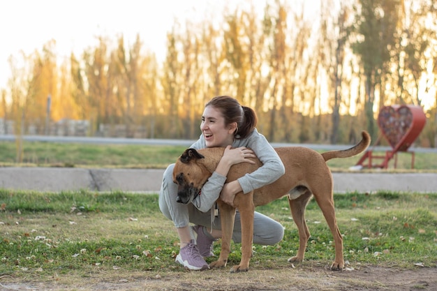 Vrouw die lacht in het park met zwerfhond