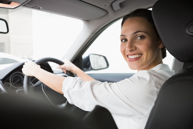 Vrouw die lacht op camera tijdens het rijden