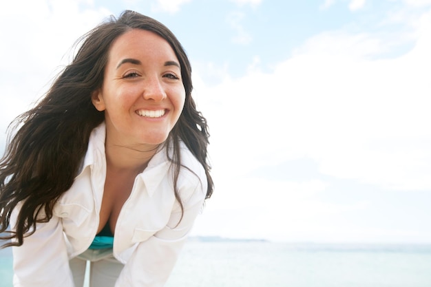 Vrouw die lacht op het strand op een zonnige dag