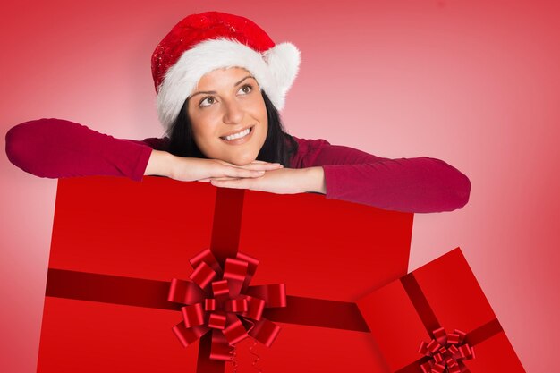 Vrouw die lacht terwijl hij wegkijkt tegen het rode kerstlint