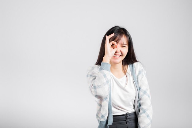 Vrouw die lacht weergegeven: gemaakte vinger Ok symbool teken om akkoord te gaan studio opname geïsoleerde witte achtergrond Gelukkig Aziatisch portret mooie jonge vrouwelijke levensstijl akkoord handteken met kopie ruimte