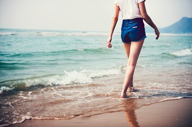 Vrouw die langs het strand loopt