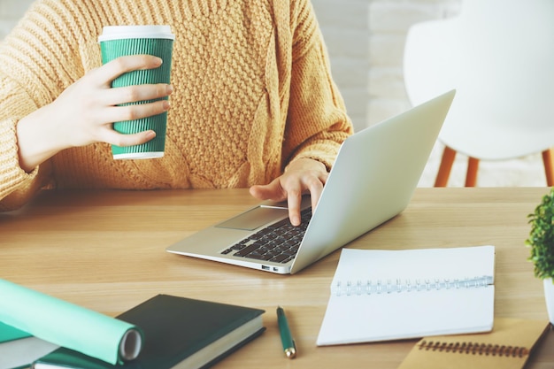 Vrouw die laptop gebruikt en koffie drinkt