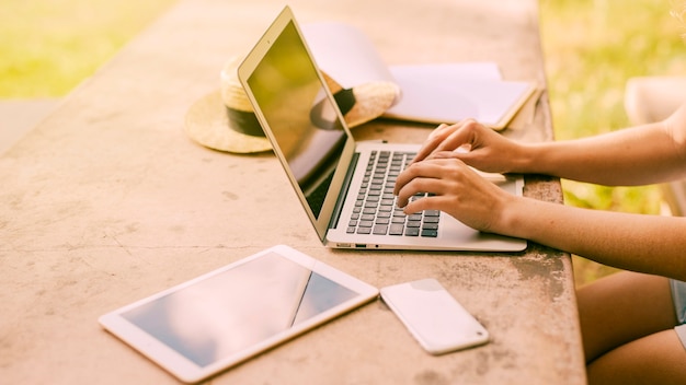 Vrouw die laptop met behulp van bij lijst in openlucht