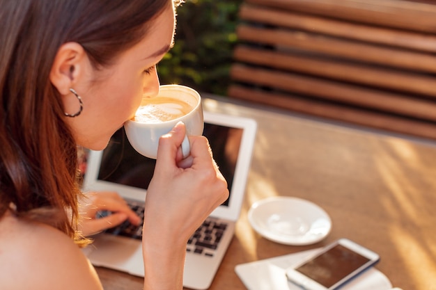 Vrouw die laptop met behulp van tijdens een koffiepauze