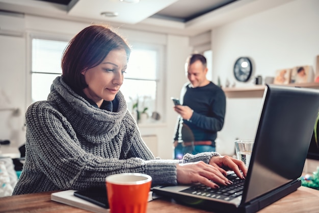 Vrouw die laptop thuis kantoor met behulp van