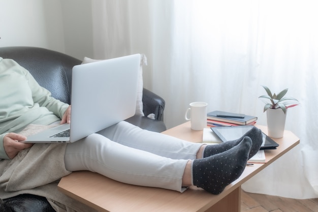 Vrouw die laptop thuis met behulp van