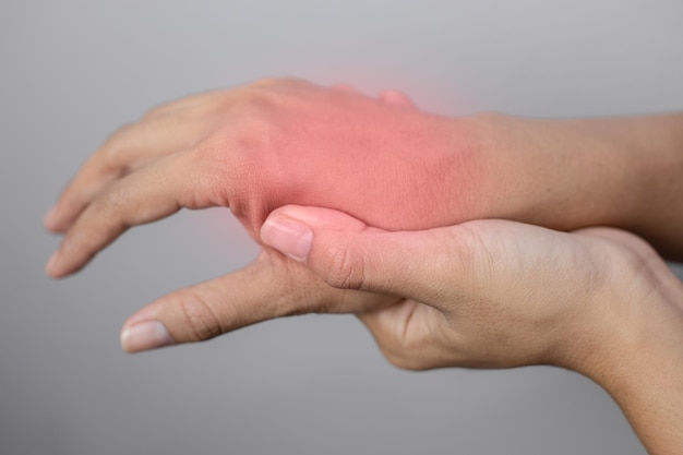 Vrouw die lijdt aan pijn in de hand. pijn in de hand. jonge vrouw houdt pijn van de hand vast.