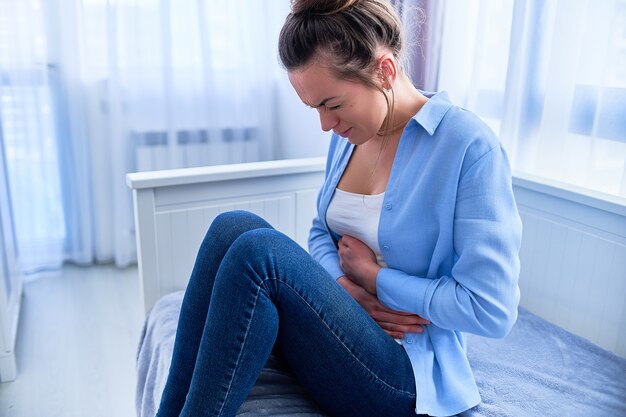 Vrouw die lijdt aan sterke spasmen, maagpijn tijdens maagzweren