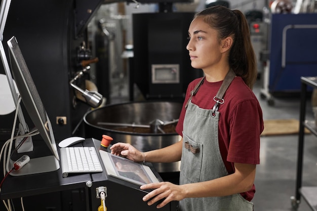 Vrouw die machines bedient bij een koffiebranderij