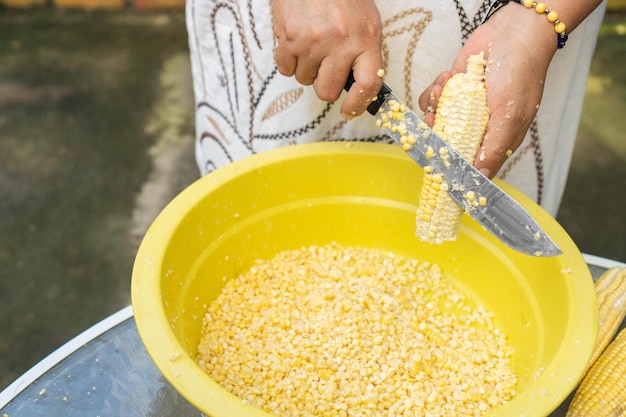 Vrouw die maïs beschiet voor het diner