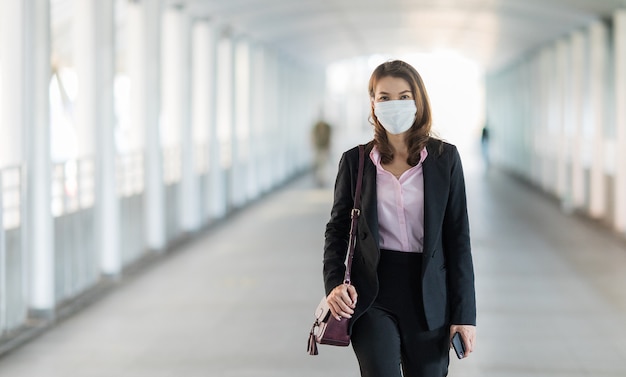 Vrouw die masker in het lopen draagt.