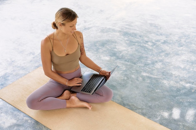 Vrouw die met computerlaptop op organische mat werkt