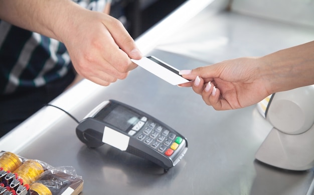 Vrouw die met creditcard in supermarkt betaalt.