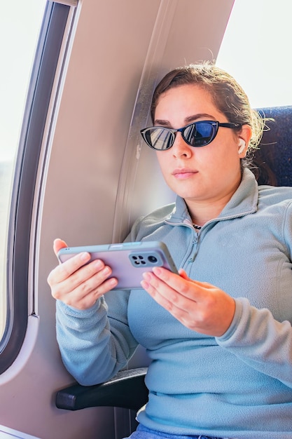 Vrouw die met de trein reist en aan een smartphone werkt