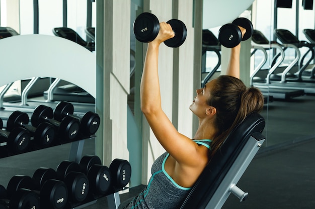 Vrouw die met domoren in gymnastiek uitwerkt