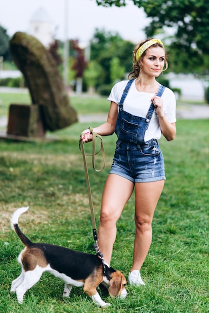 Vrouw die met een hond loopt, en dromerig uit eruit ziet eruit ziet. -Beeld