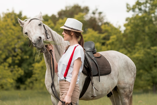 Foto vrouw die met een paard in het platteland loopt