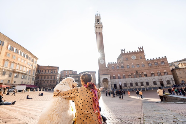 Vrouw die met hond reist in de stad Siena in Italië