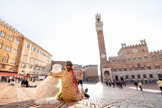 Vrouw die met hond reist in de stad Siena in Italië