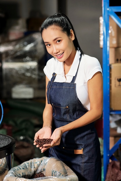 Vrouw die met koffie aan fabriek werkt