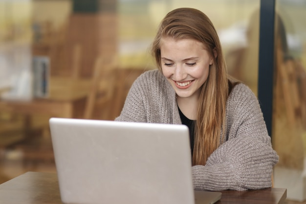 Vrouw die met laptop in café werkt