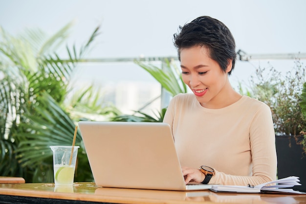 Vrouw die met laptop in café werkt