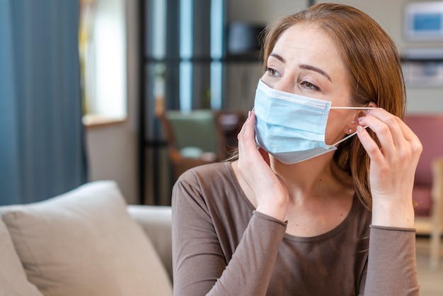 Vrouw die met masker in quarantaine blijft die weg eruit ziet