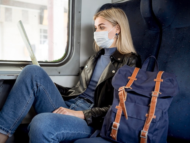 Vrouw die met trein reist en masker draagt