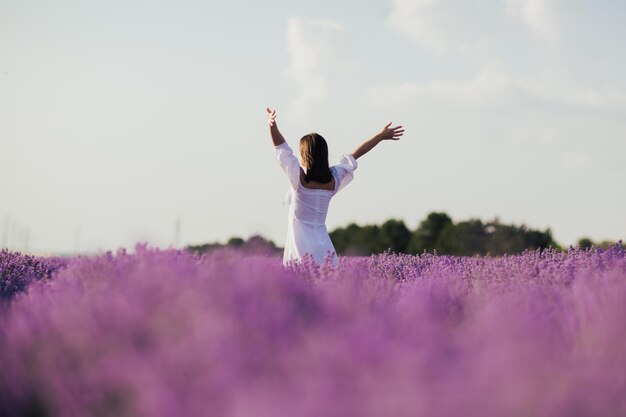 Vrouw die midden in een lavendelveld staat