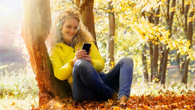 Vrouw die mobiele telefoon in park met behulp van