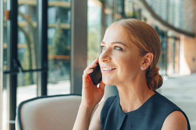 Foto vrouw die mobiele telefoon op het kantoor met behulp van