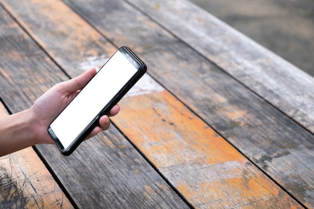 Foto vrouw die mobiele telefoon op houten raad met behulp van