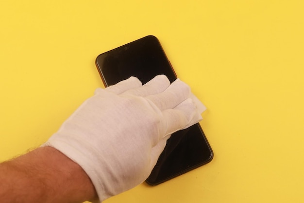 Vrouw die mobiele telefoon schoonmaakt met antiseptisch doekje