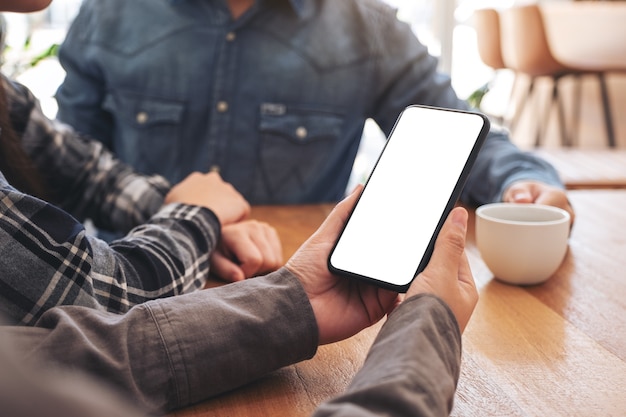 Vrouw die mockup mobiele telefoon gebruikt en bekijkt met vrienden op kantoor