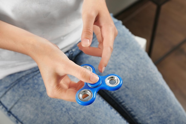 Vrouw die moderne spinner binnenshuis rolt