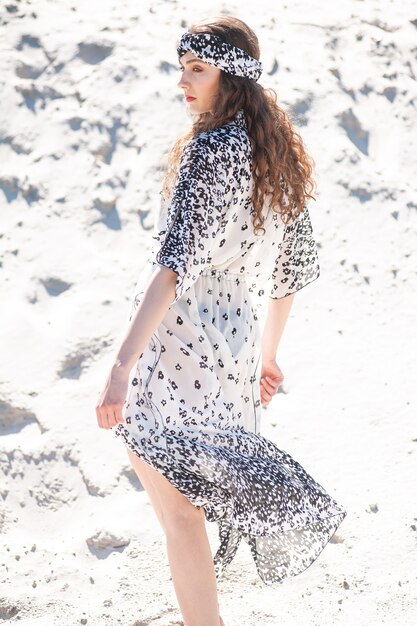 Vrouw die modetuniek draagt op het strand