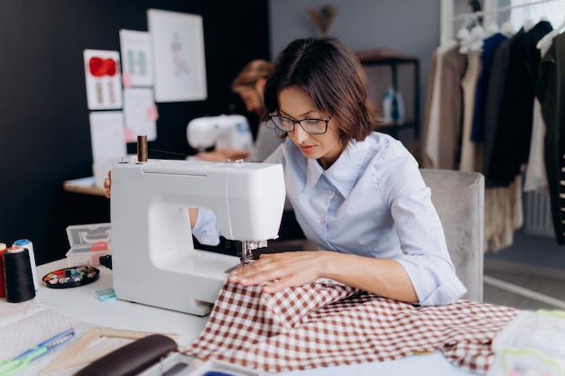 Vrouw die naaimachine met behulp van