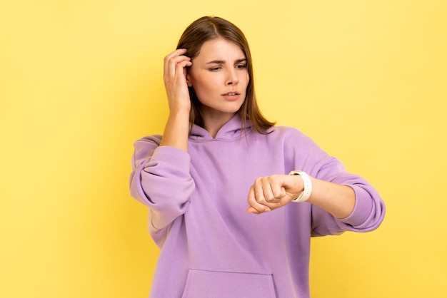 Vrouw die naar een polshorloge kijkt en een afspraak maakt met de tijd om haar haar met de hand aan te raken