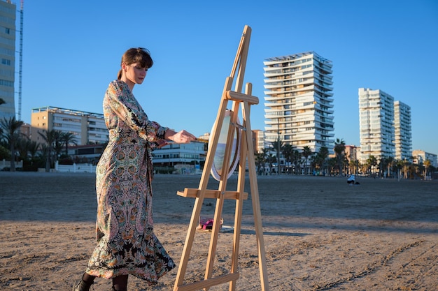 Vrouw die naast een ezel op het strand staat