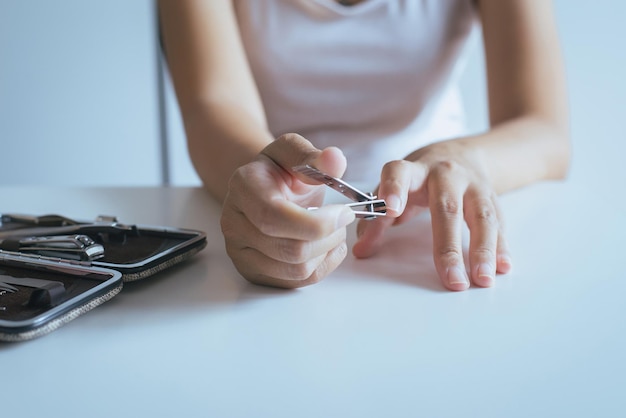 Vrouw die nagels knipt met nagelknipperVrouwen die een pincet gebruiken